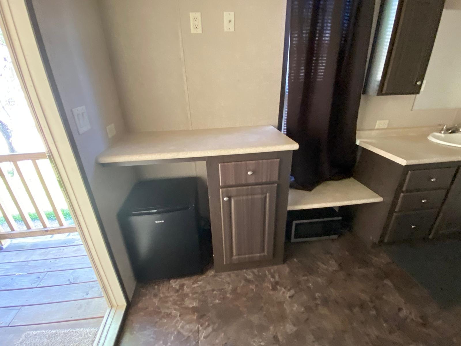 Studio kitchen area with mini fridge, microwave, and cabinetry